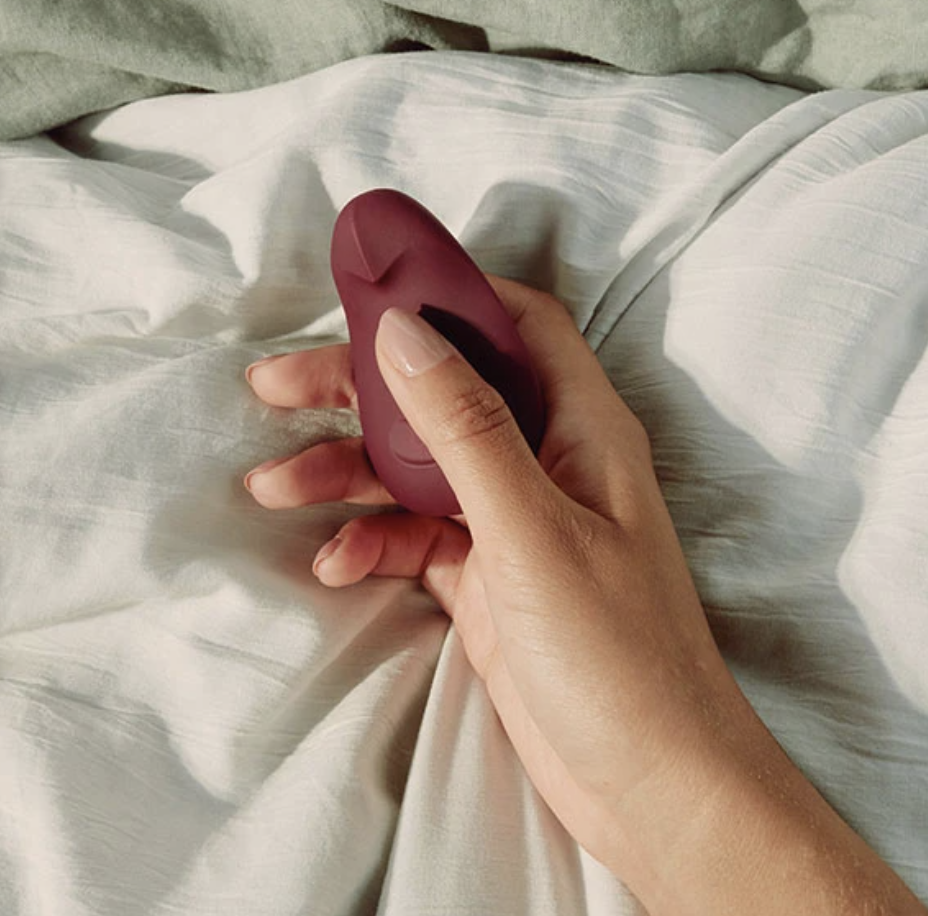 Experienced redhead masturbating with vibrator lying on the bed